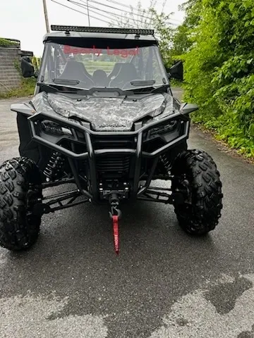 A black atv parked on the side of a road.