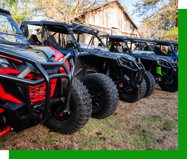 A row of all terrain vehicles parked in the grass.