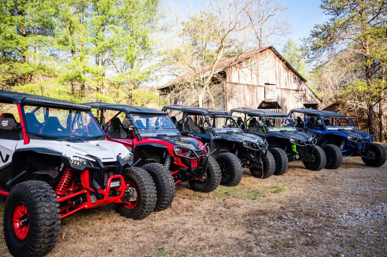 A row of all terrain vehicles parked in the dirt.